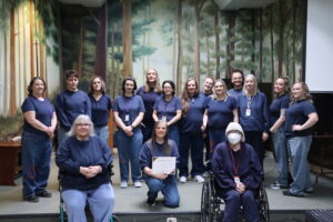 Coffee Creek Large Group Large group of incarcerated women standing in a group holding Roots of Success certificates.