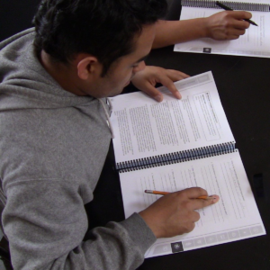 student_workbook Student sitting down reading a Roots of Success manual.